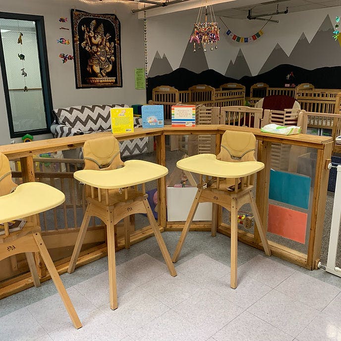 High chairs and cribs in a daycare room