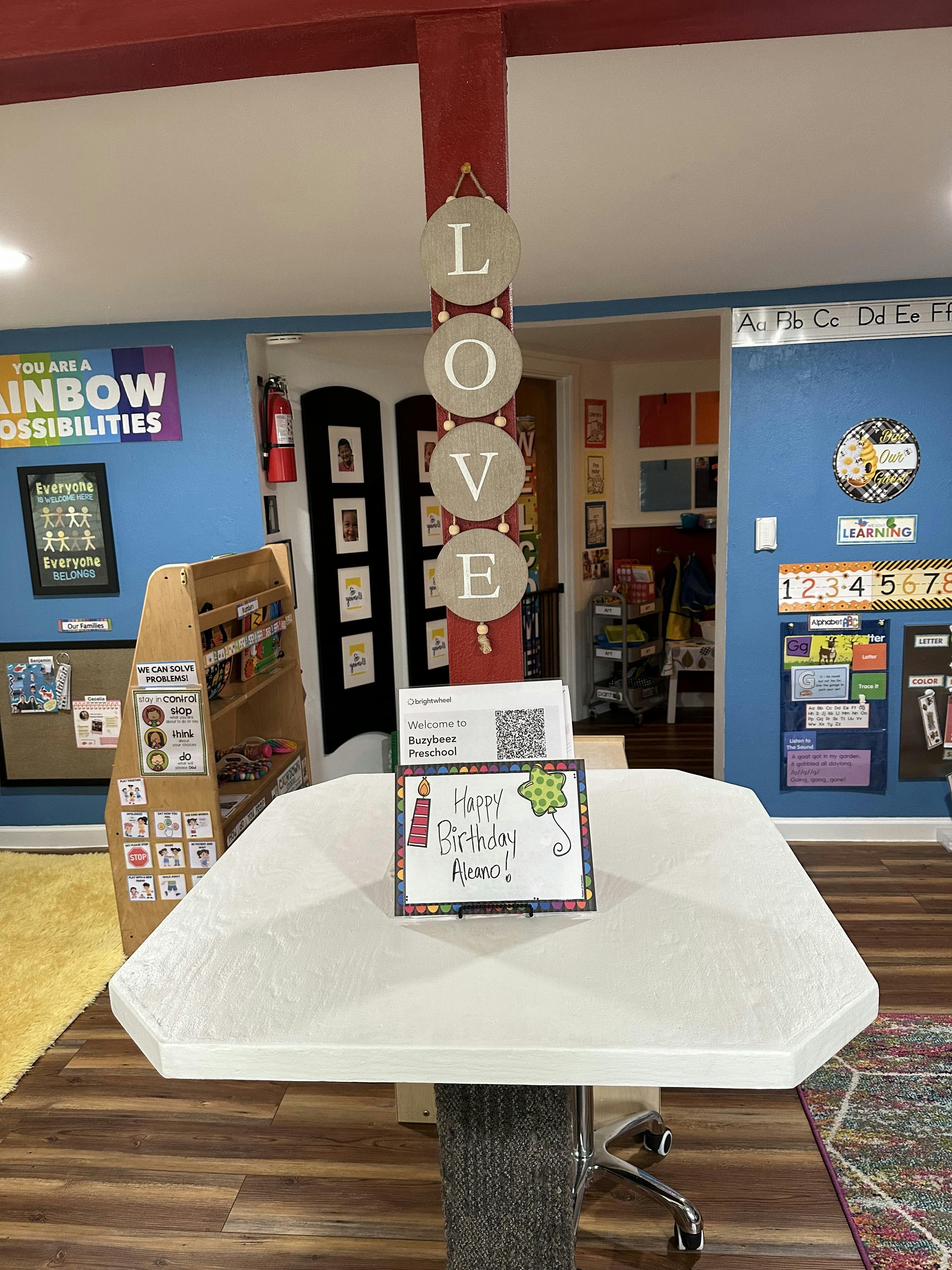 Table with a "Happy Birthday" sign in a room with "LOVE" decor