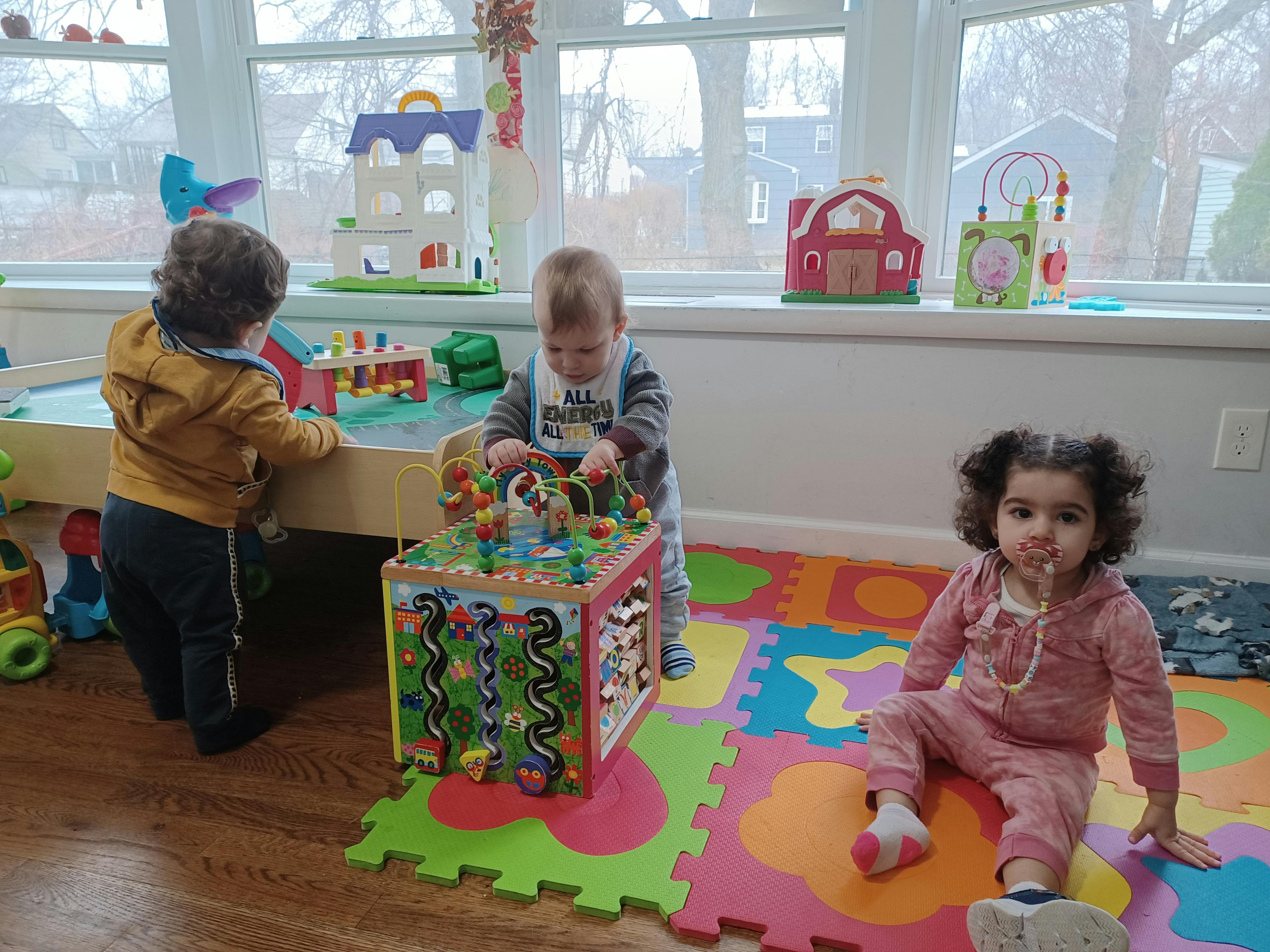 Three children playing with toys in a room