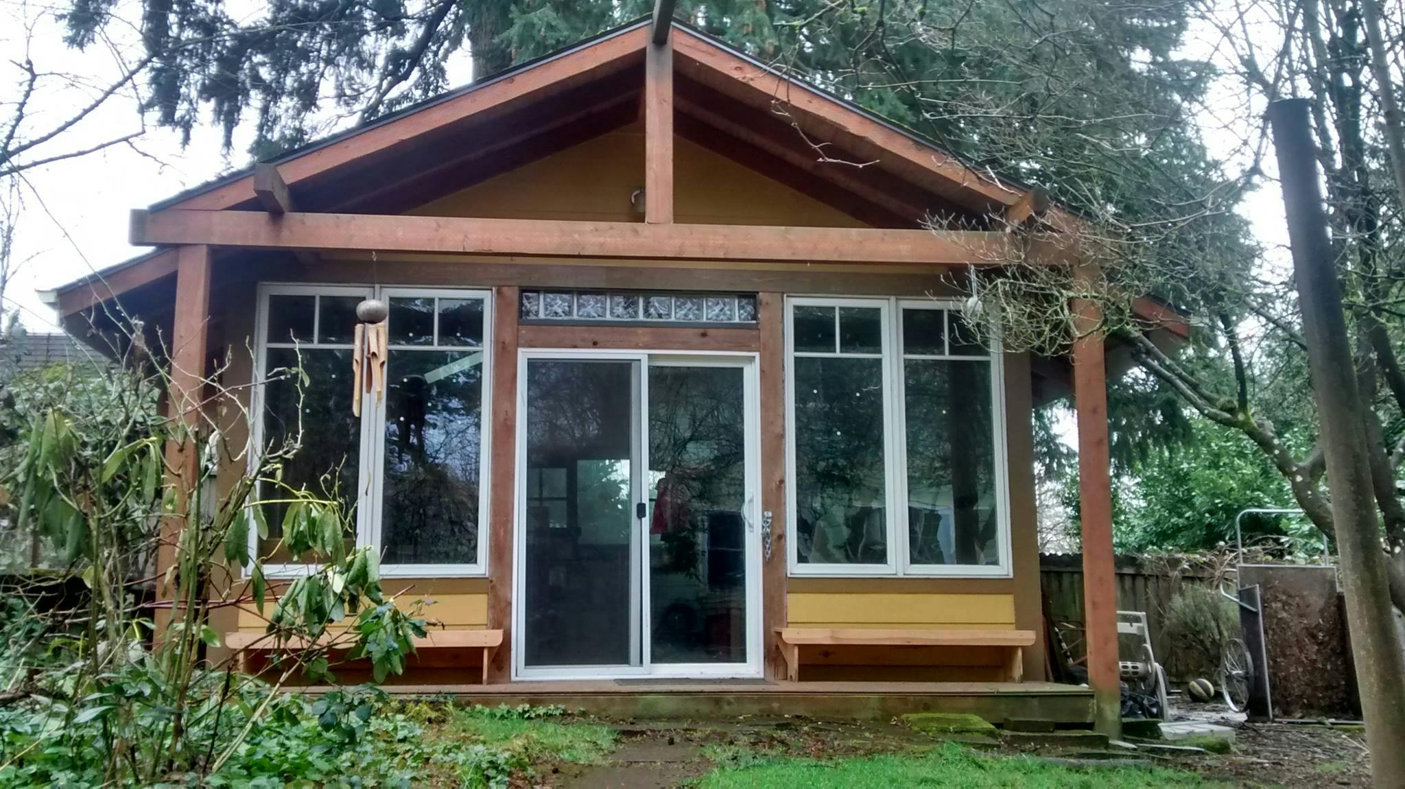 Small yellow building with large windows and sliding glass doors