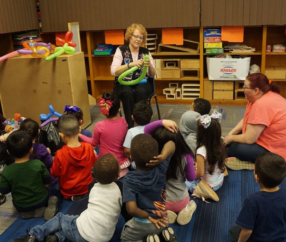 Person making balloon animals for a group of children
