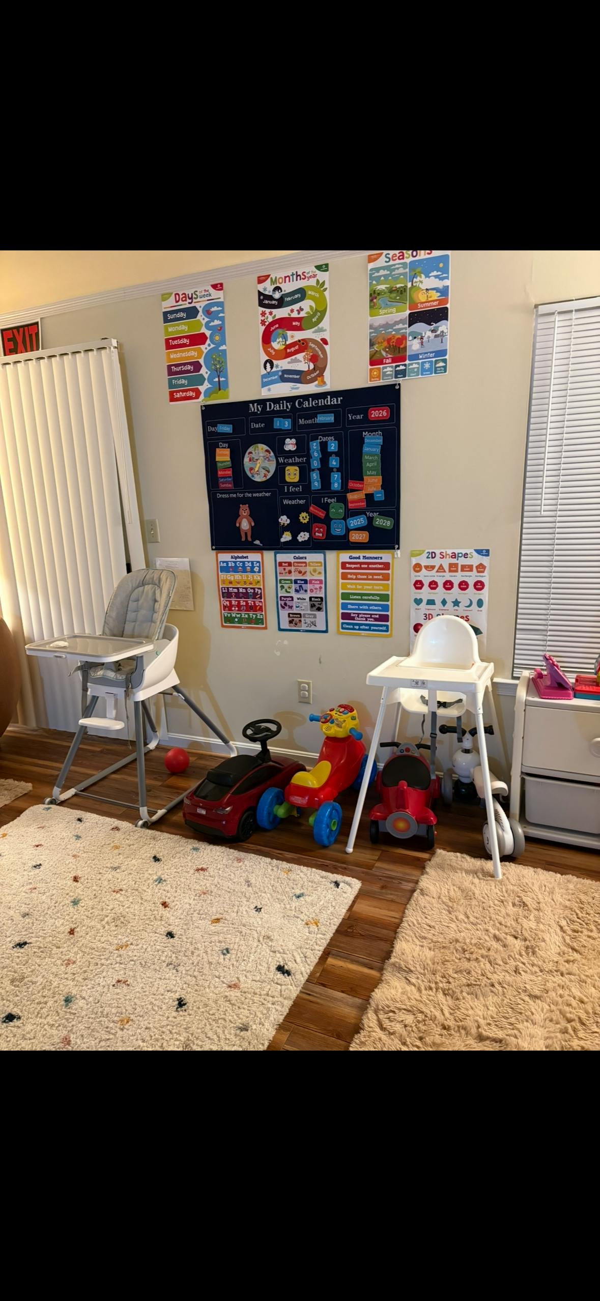 Playroom with high chairs, ride-on toys, and educational wall posters