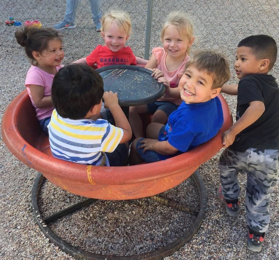 Children playing on a playground merry-go-round