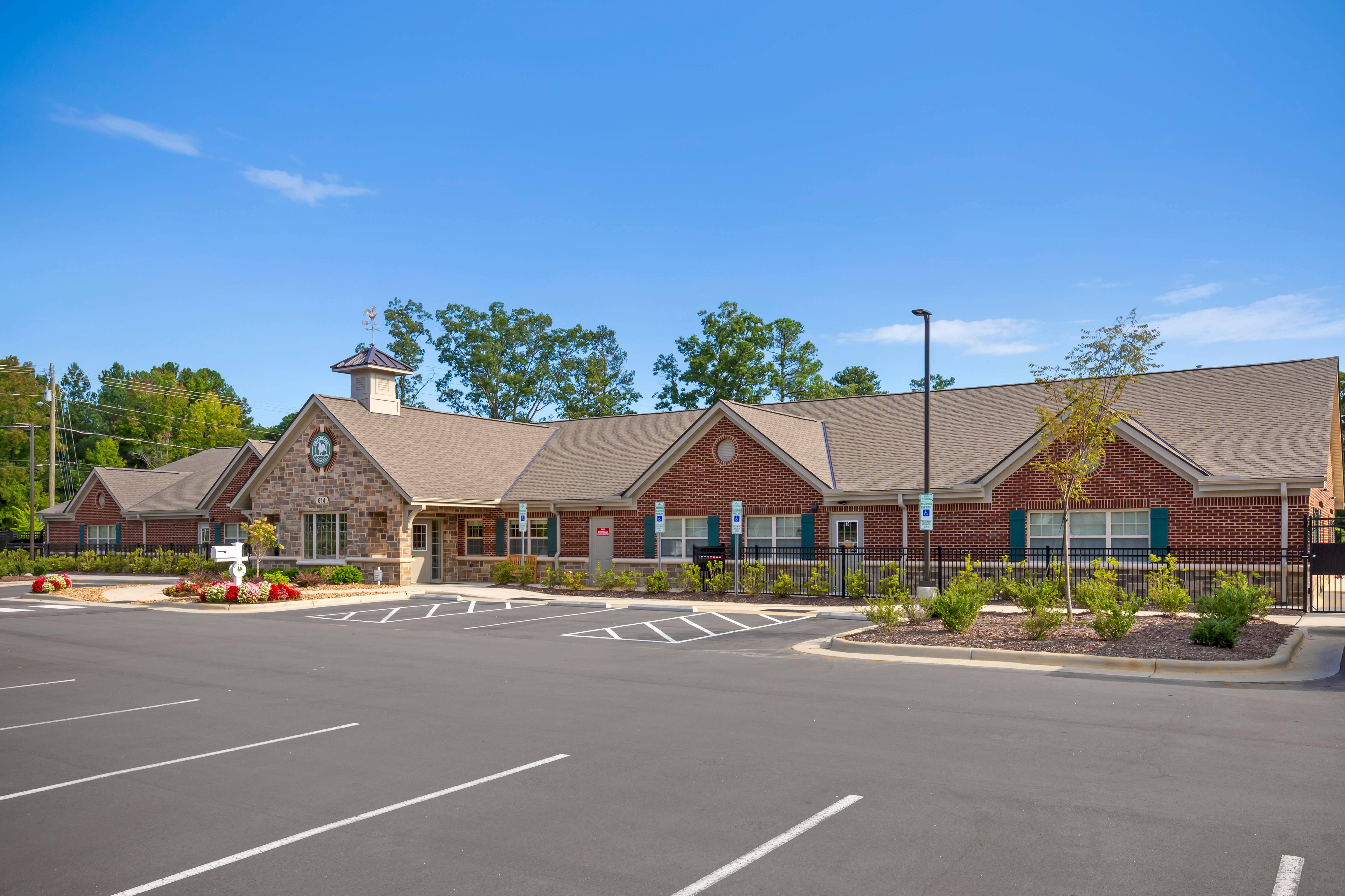 An office building with a stone front and a brick main section, with an empty parking lot