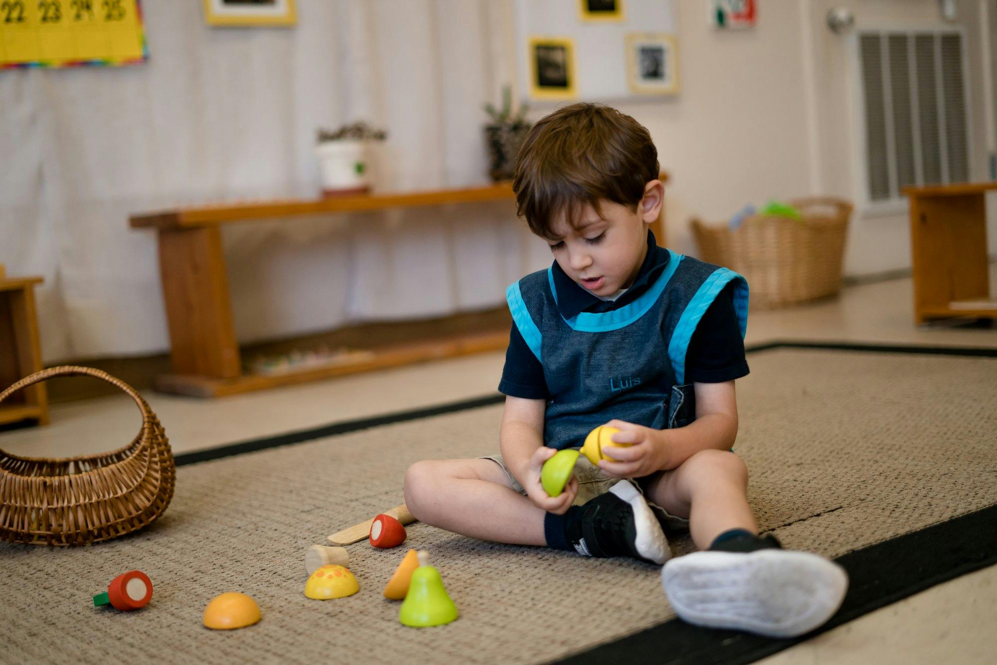 Child sitting on floor playing with toy fruit