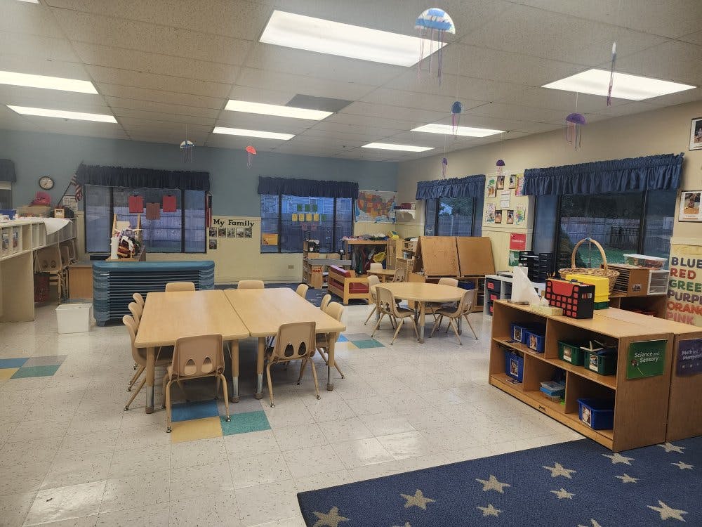 An empty classroom with small tables and chairs
