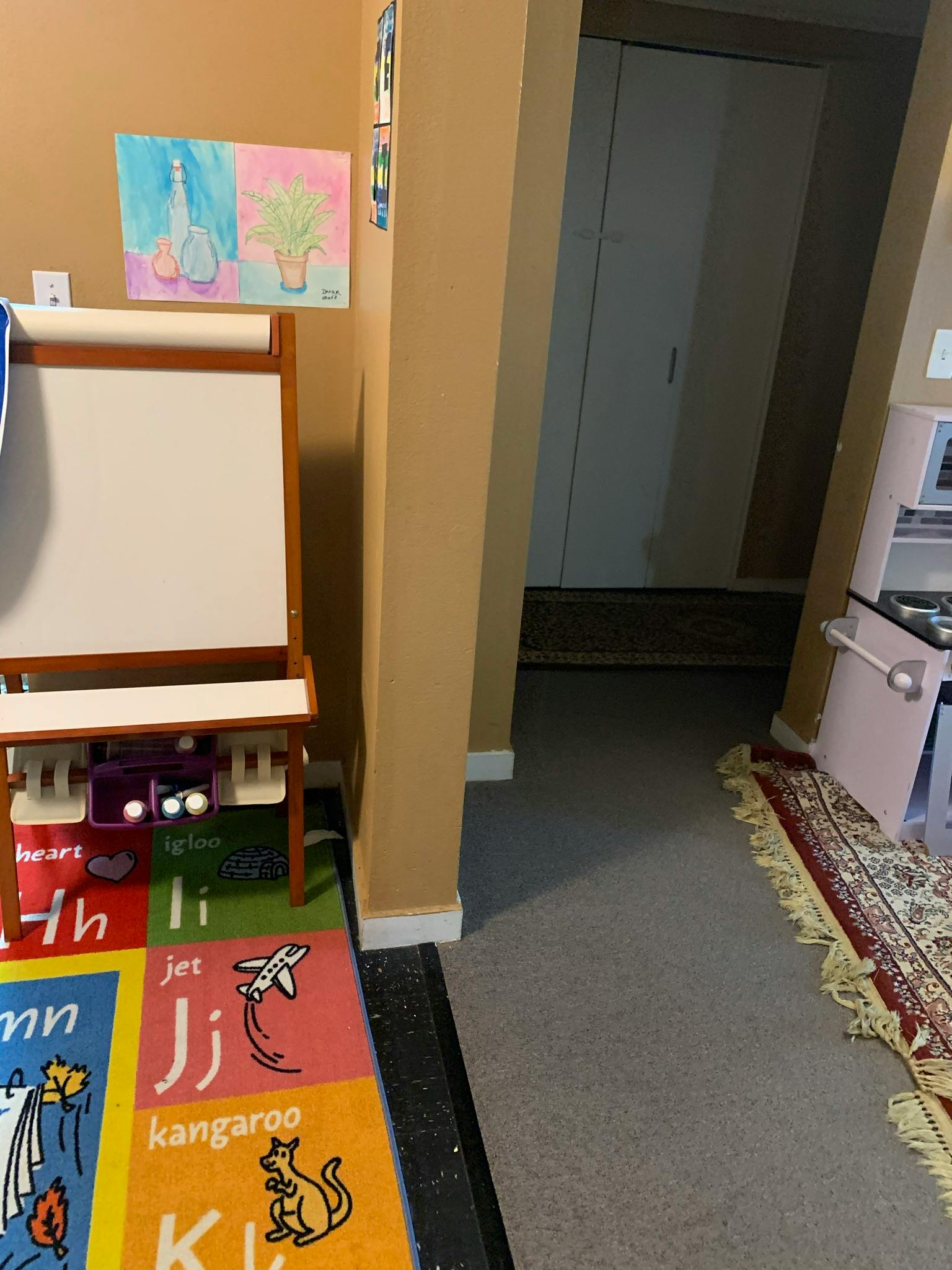 Child's easel with a colorful alphabet rug in front