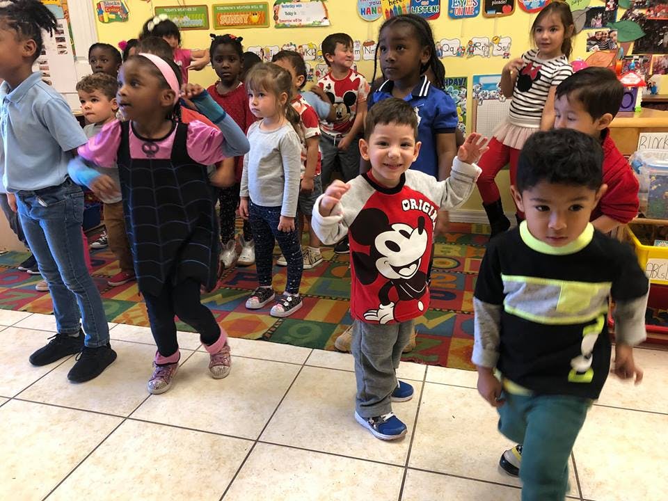 Group of children standing in a classroom