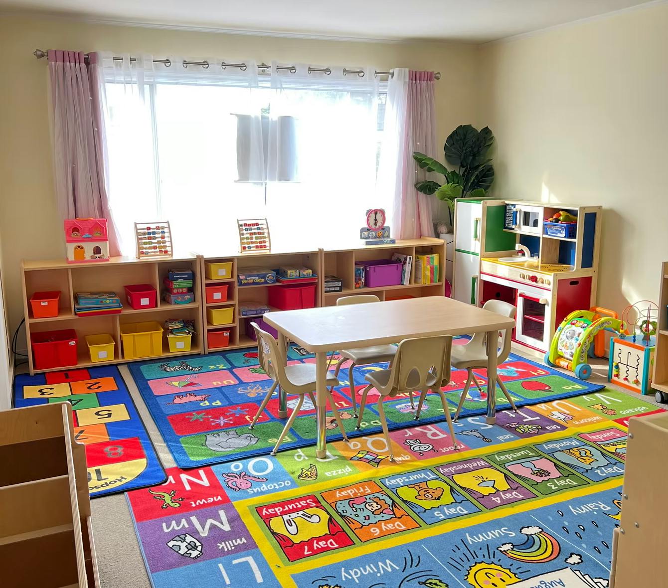 Classroom with colorful rugs, small table and chairs, and storage shelves