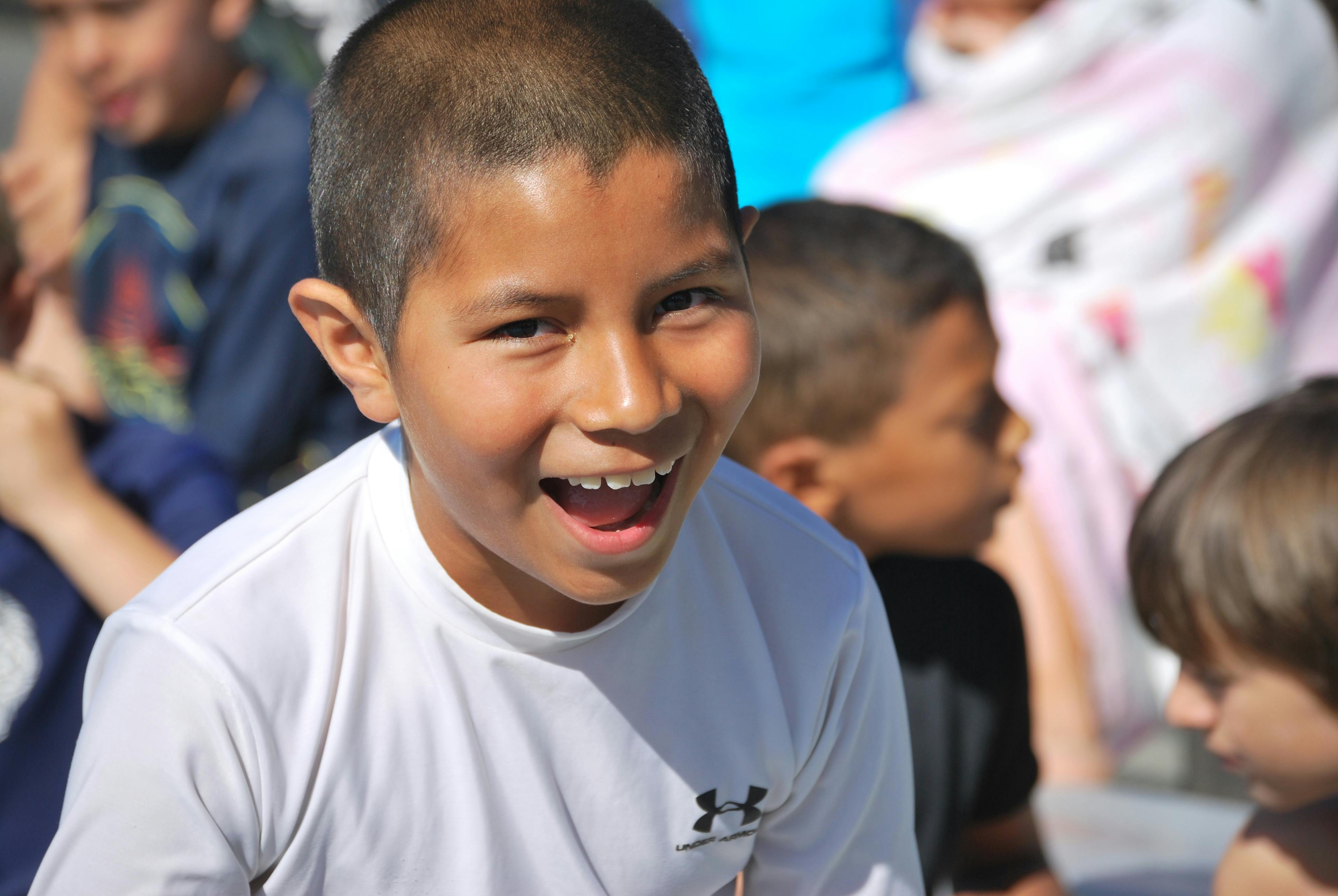 Child with short hair smiling with mouth open