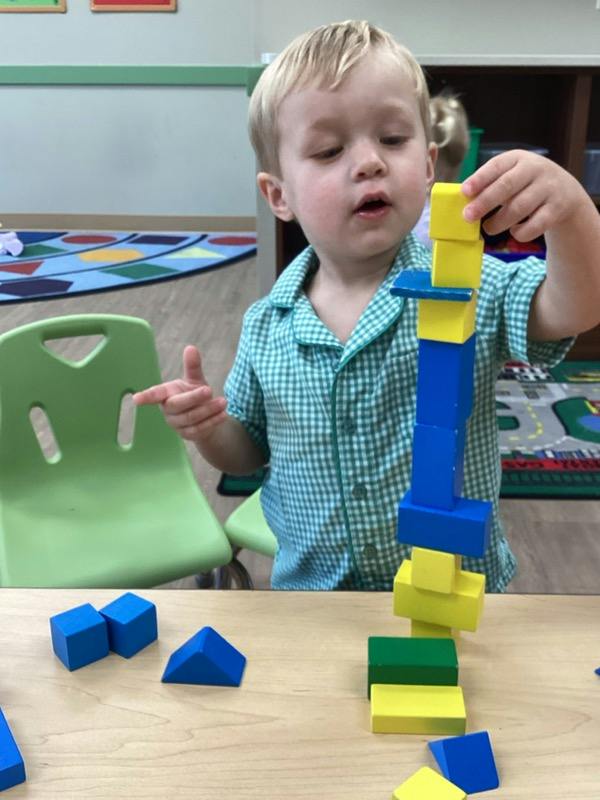 Child building a tower with colorful wooden blocks