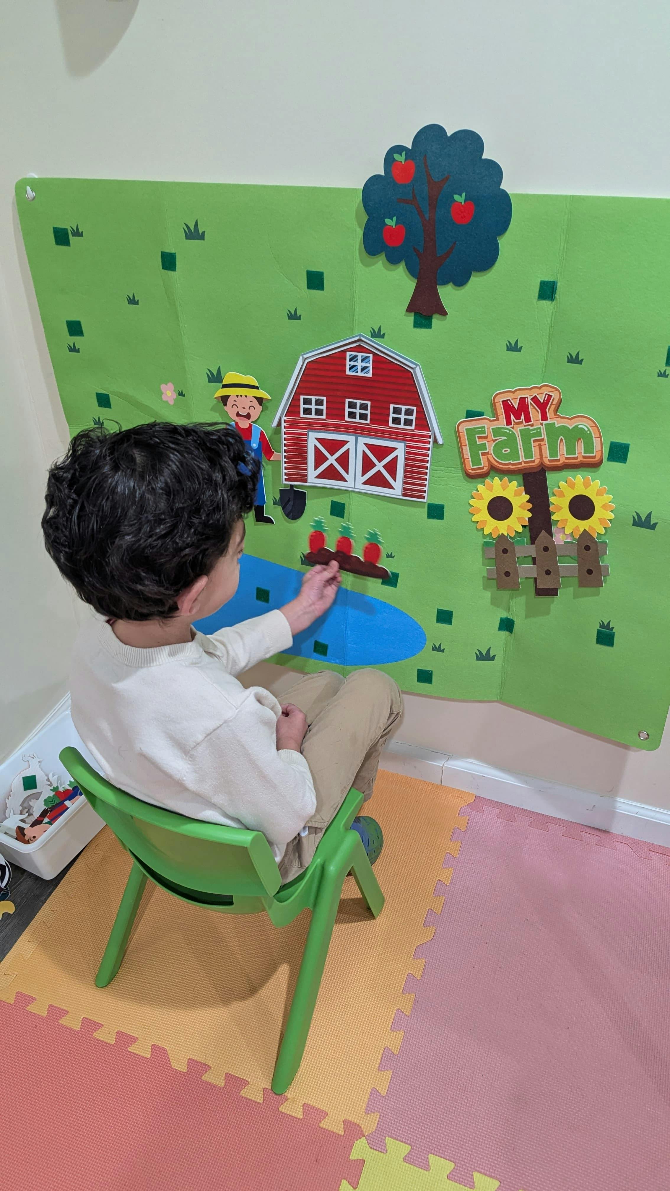 Child playing with a felt My Farm activity board