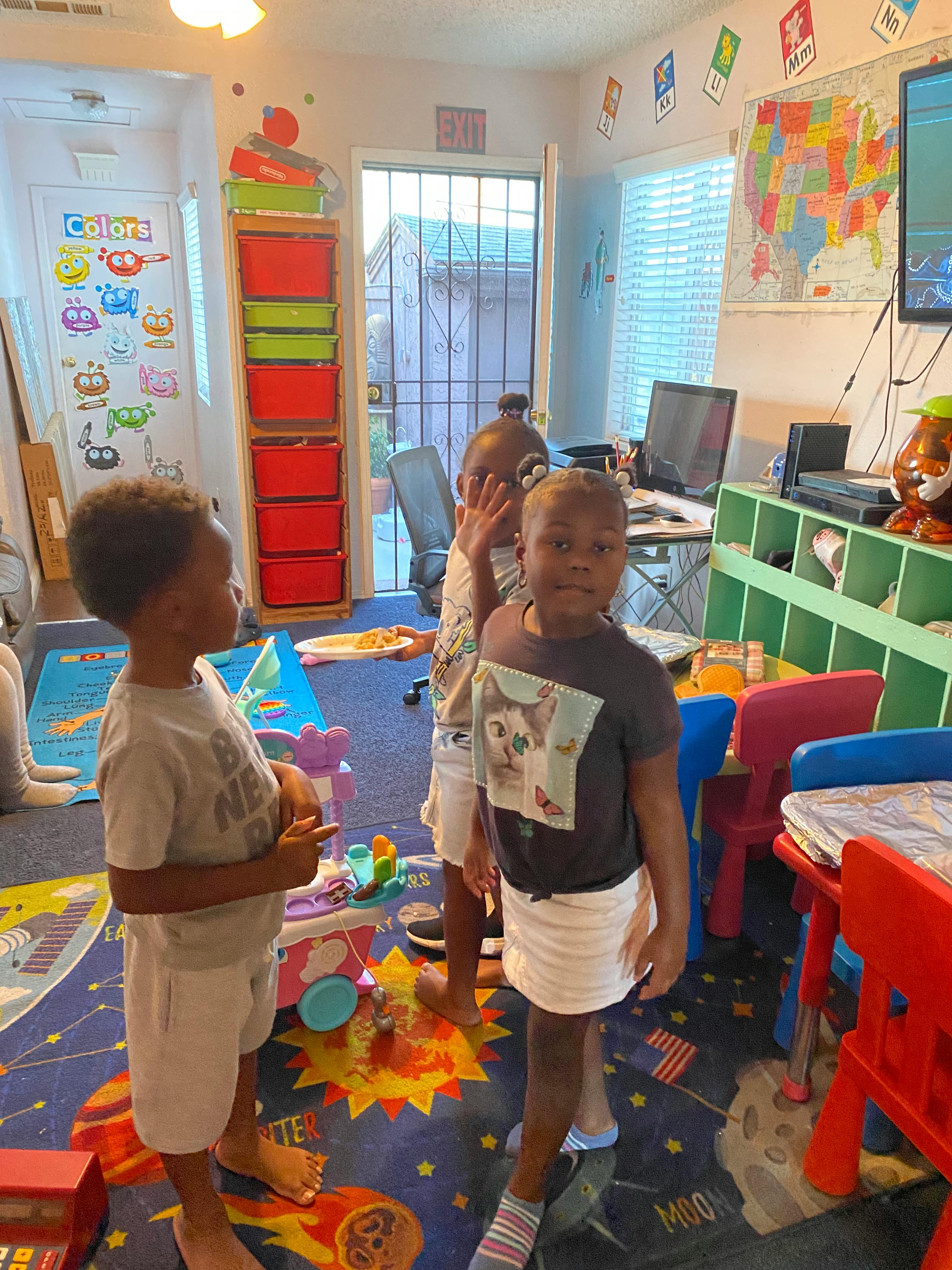 Three children playing in a classroom