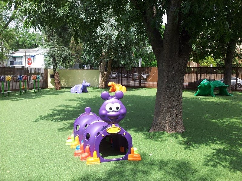 Playground with a purple caterpillar tunnel and other play equipment