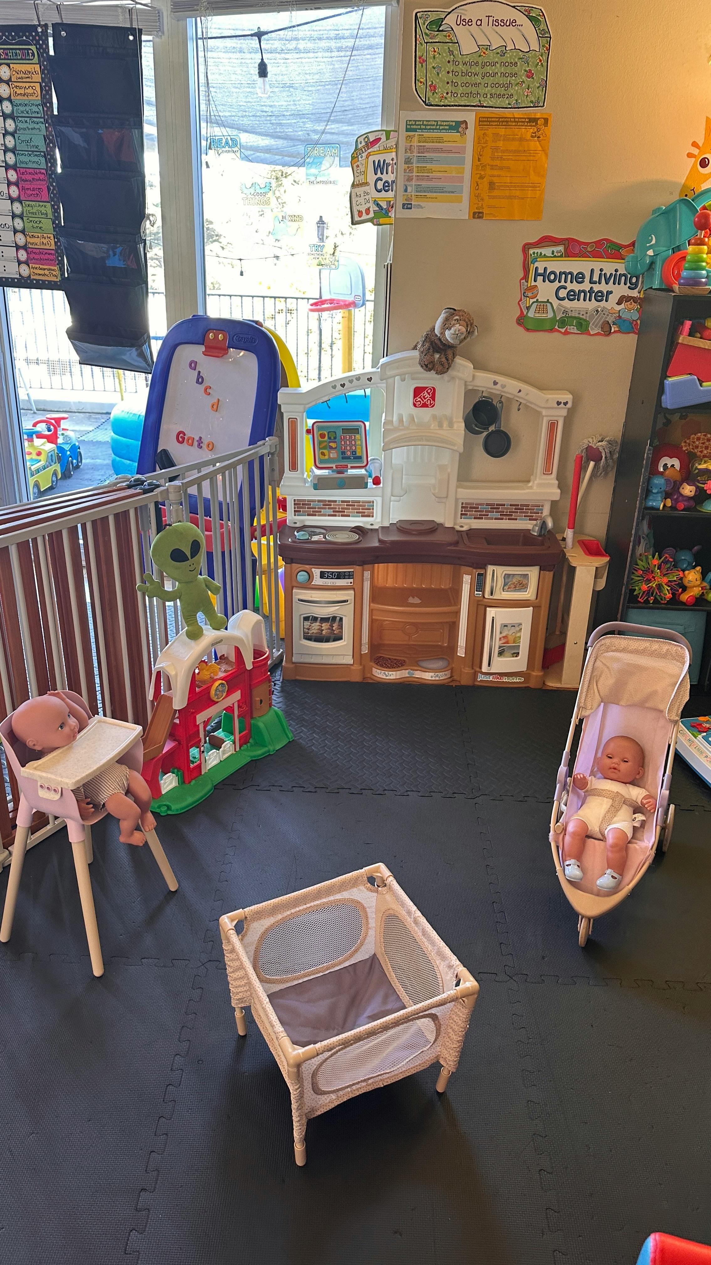 Playroom with toy kitchen, doll in high chair, doll in stroller, and playpen