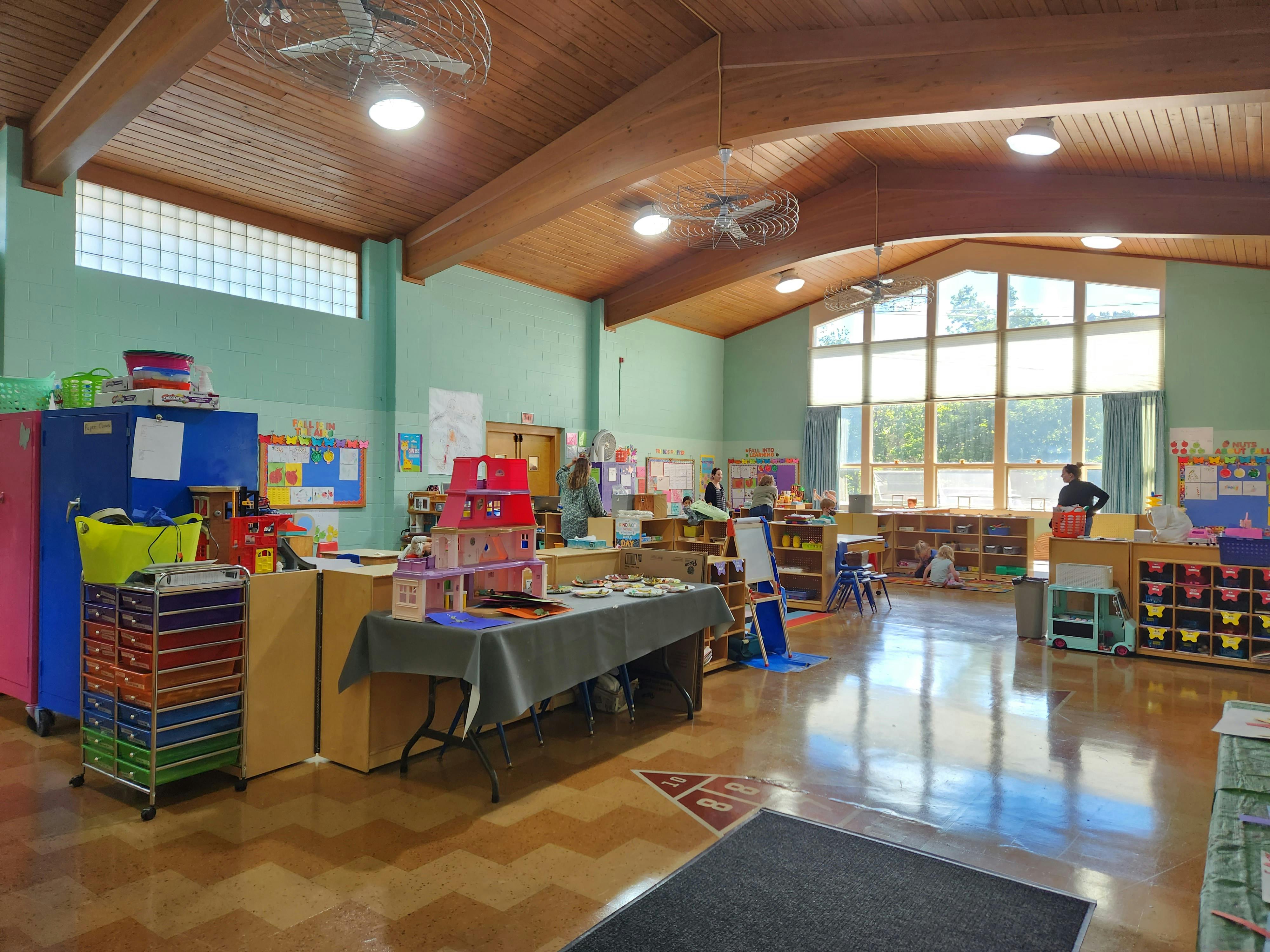 Classroom with tables, storage units, and large windows