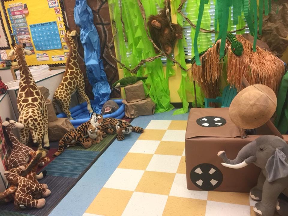 Stuffed animal giraffes, tigers, and an elephant in a decorated room