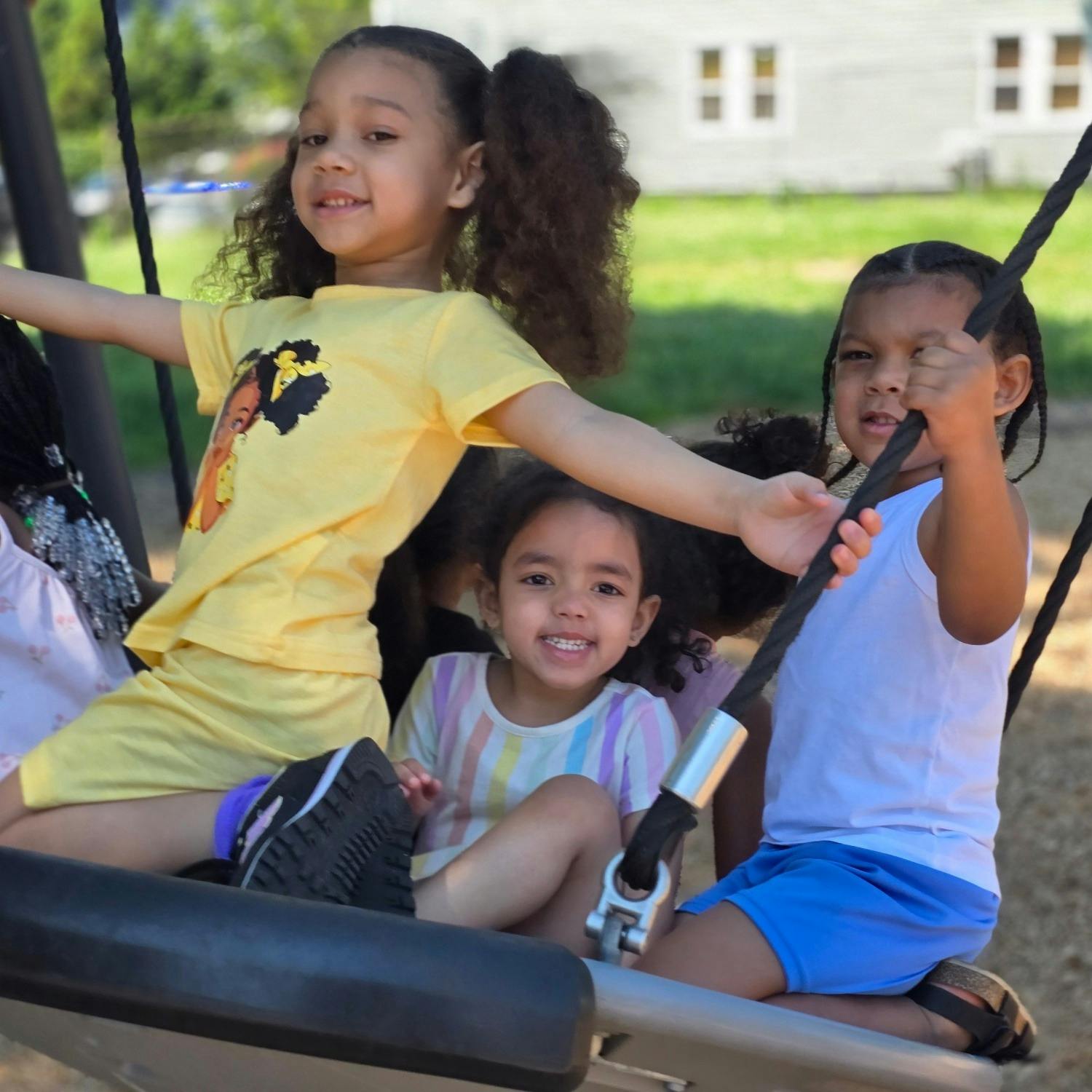 Group of children playing together on a playground swing