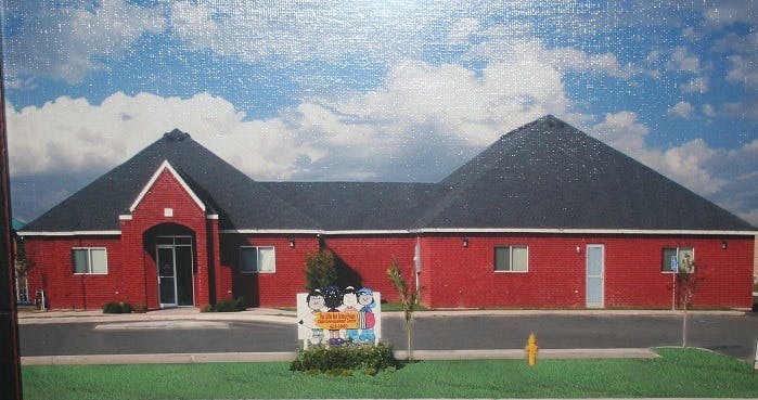 Red building with a dark roof and a sign in front