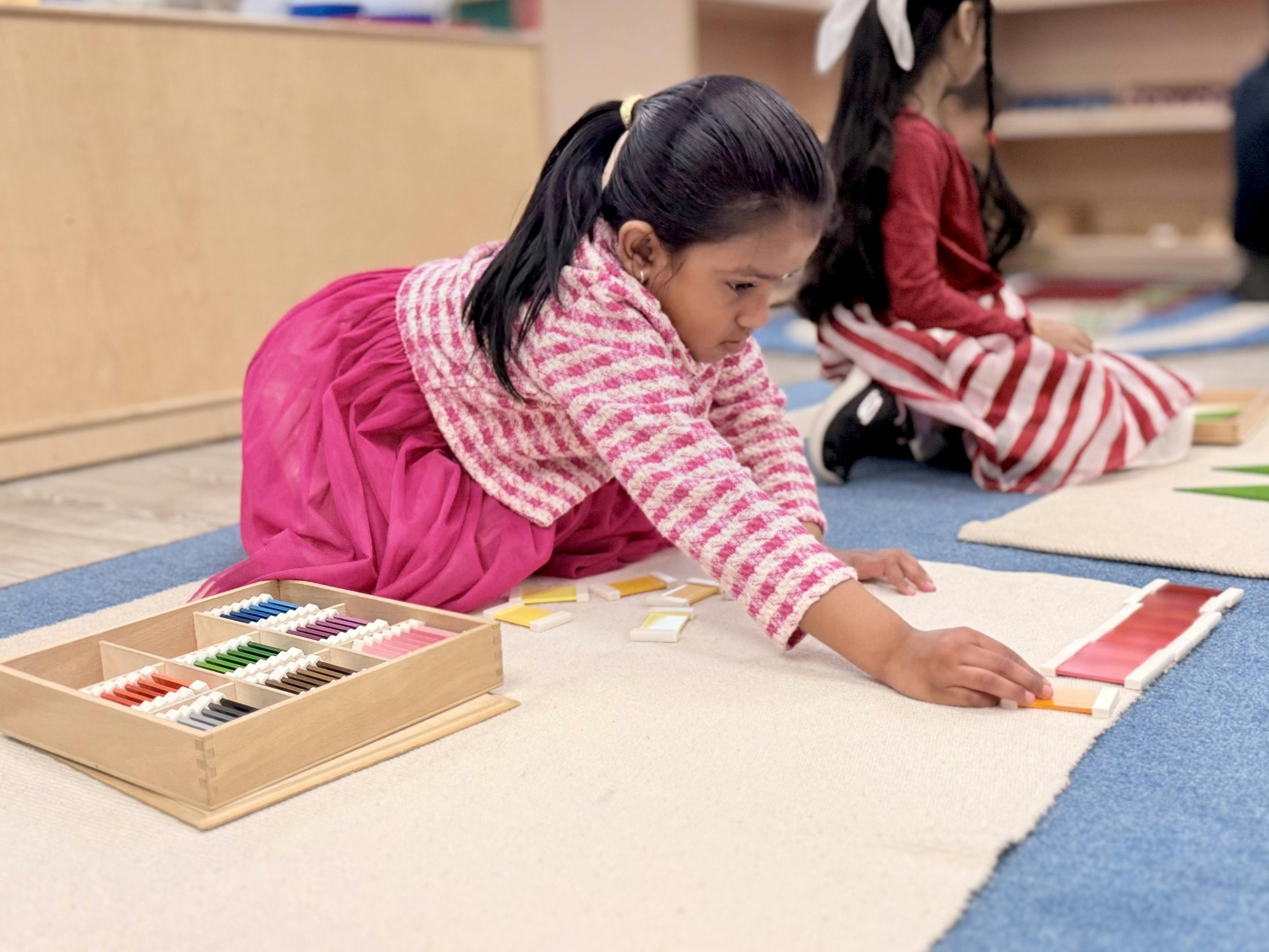 Child on floor playing with colorful learning blocks