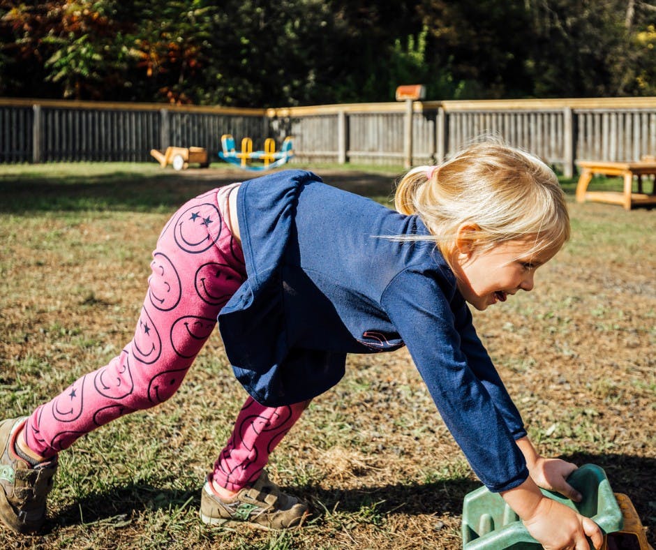 Child playing with a toy truck outdoors