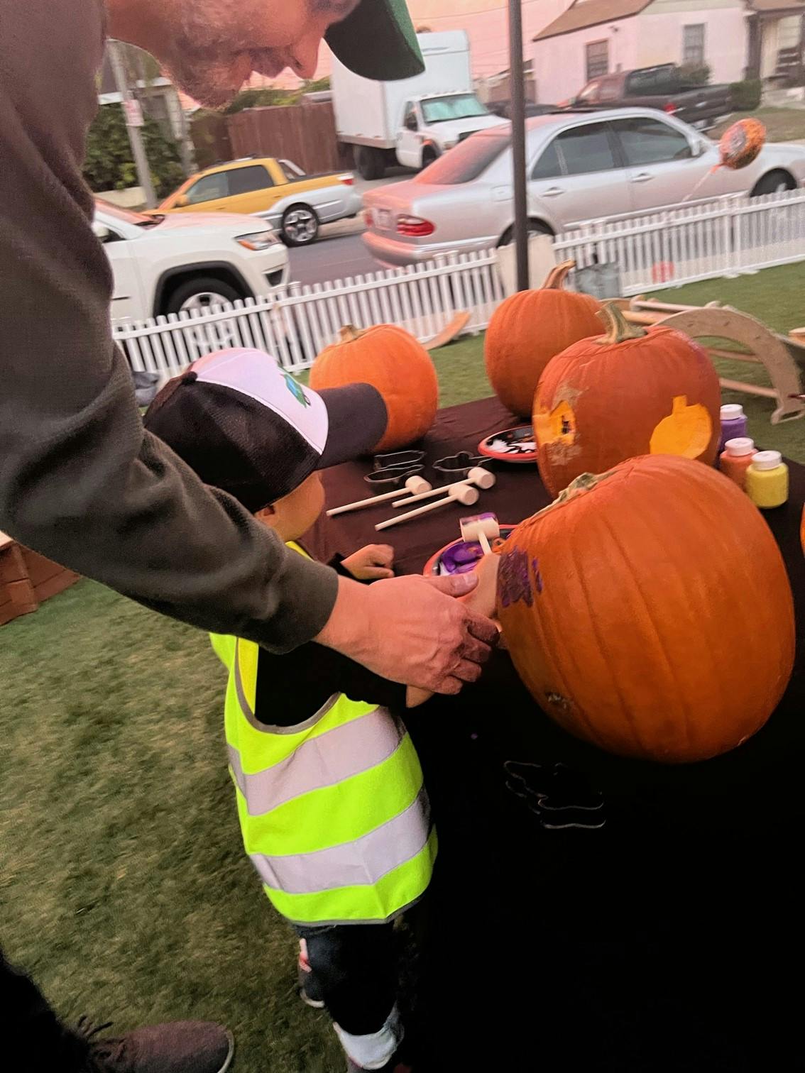 Person and child decorating pumpkins