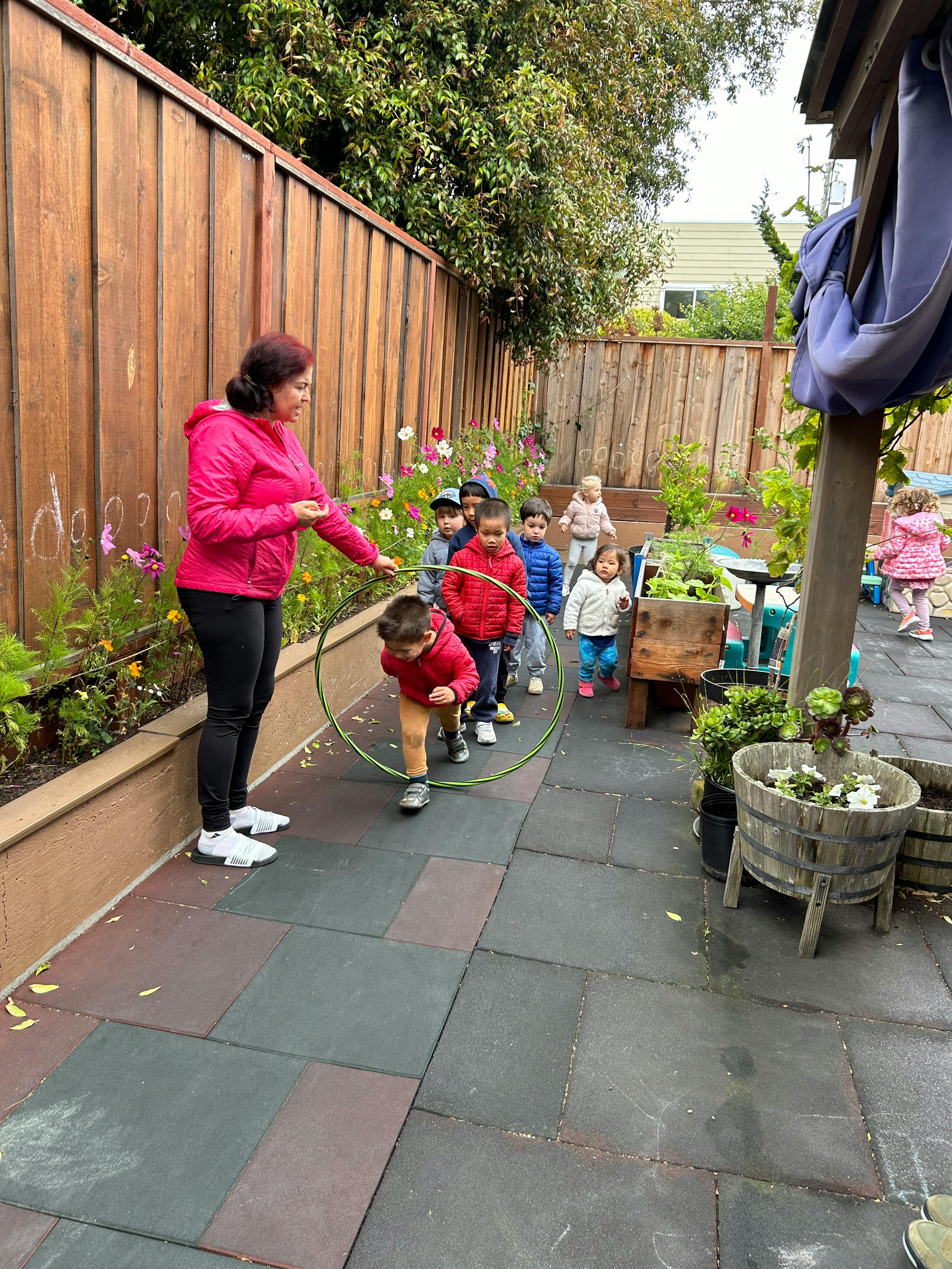 Adult and children playing with a hula hoop outdoors