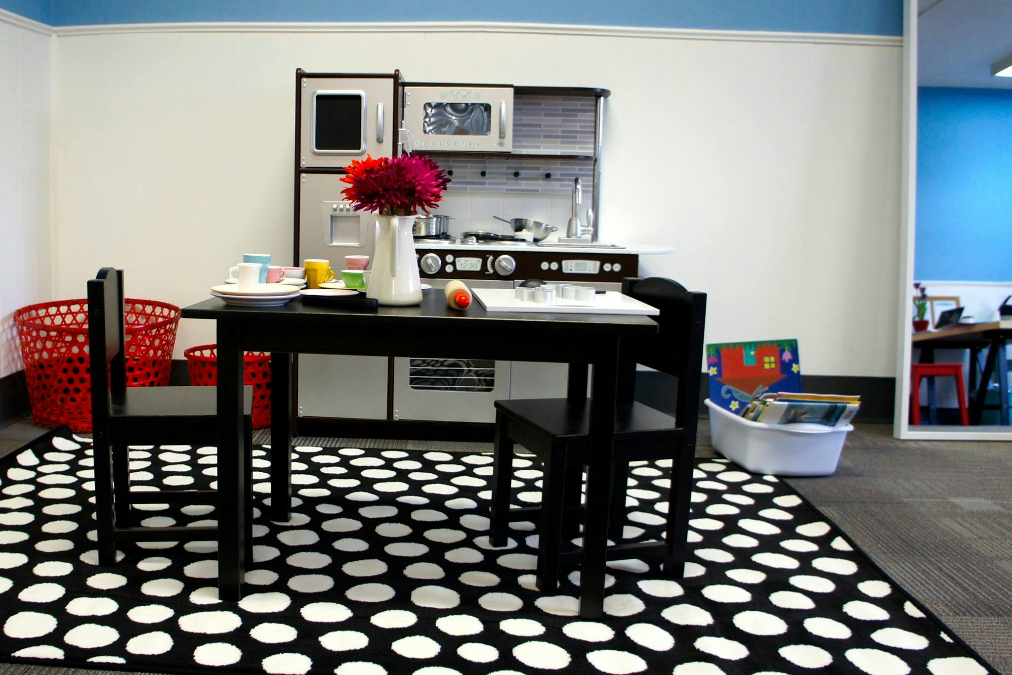 Play kitchen with a table and chairs on a polka dot rug