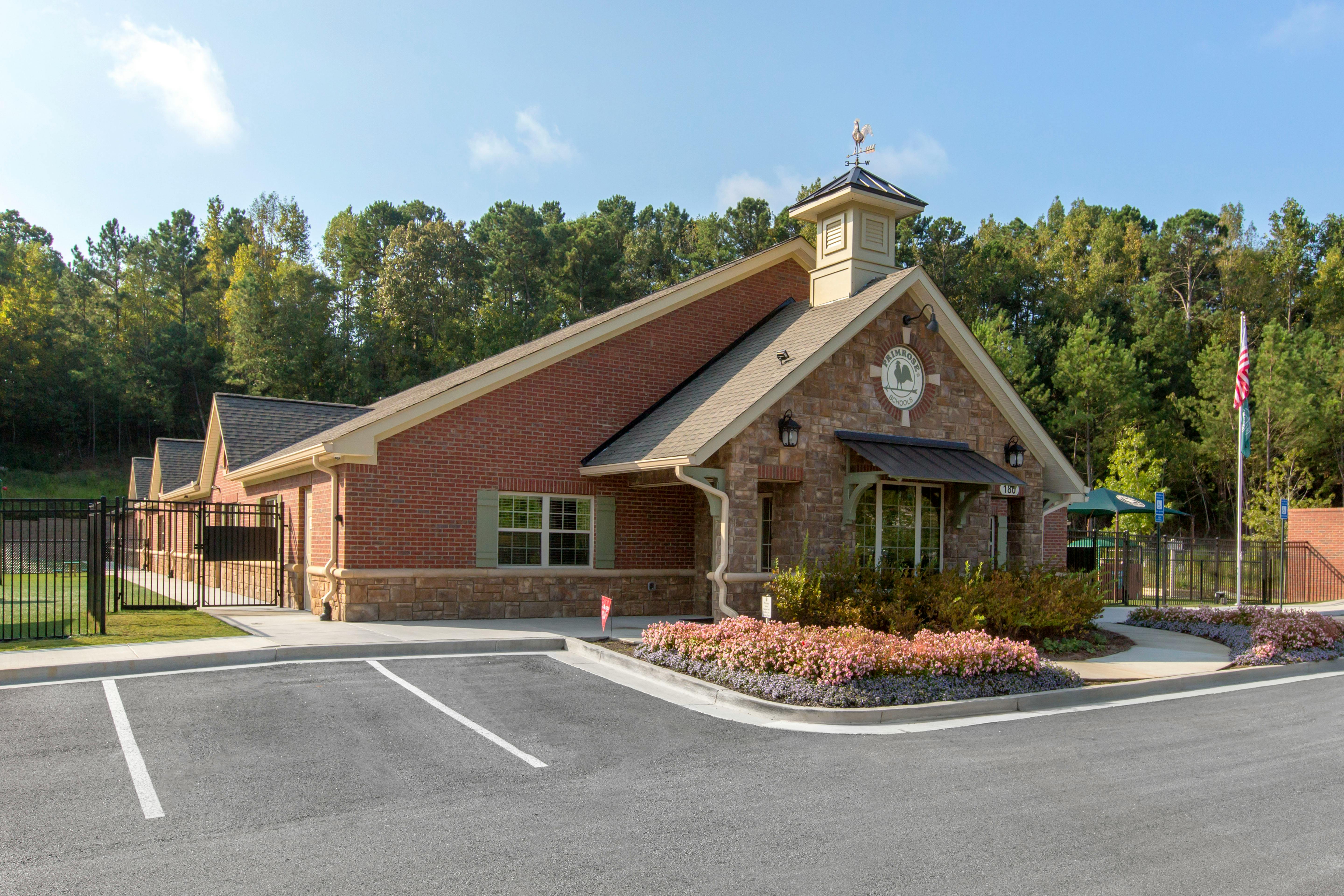Brick building with stone accents, a cupola, and a Primrose Schools sign
