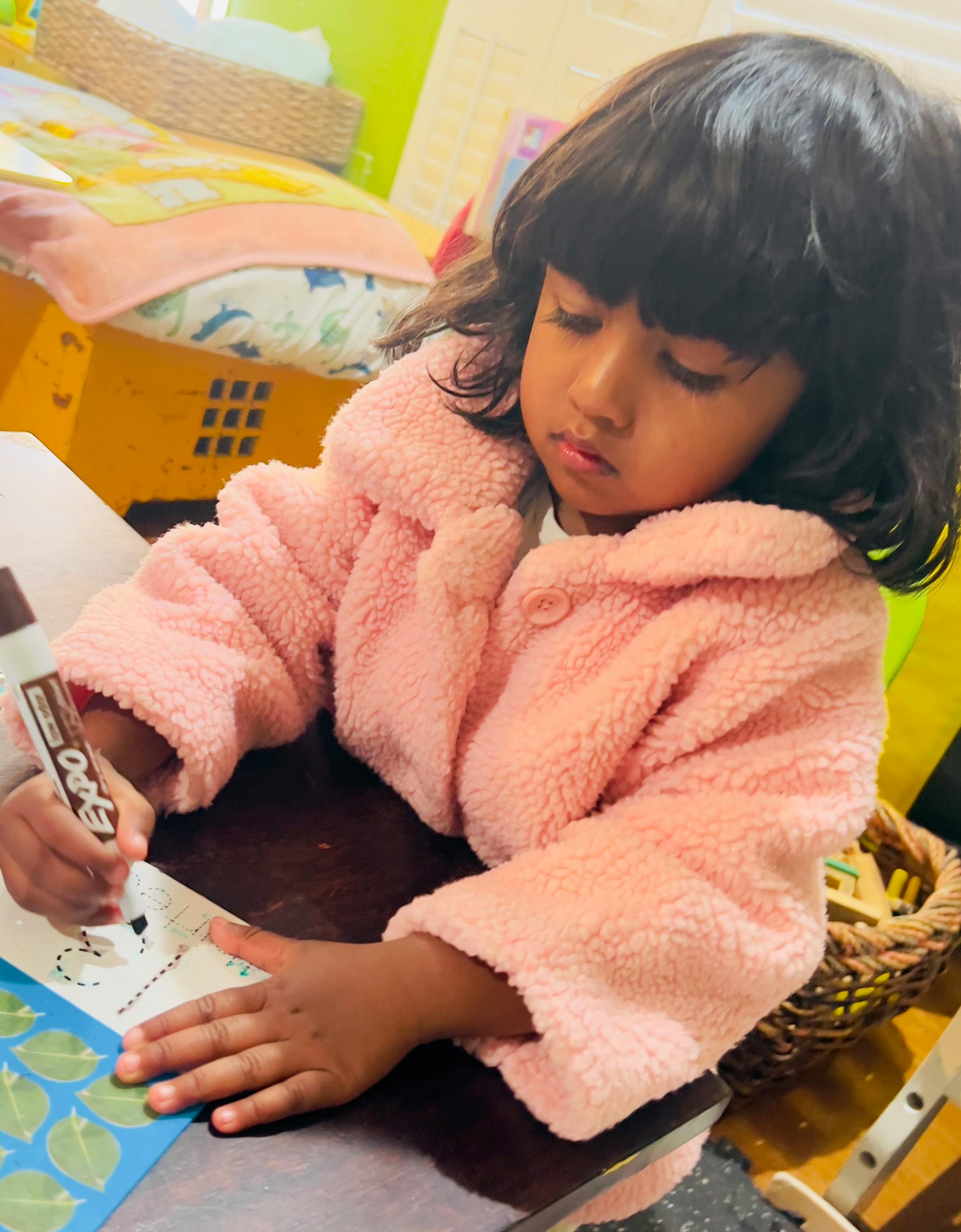 Child drawing on paper with a marker