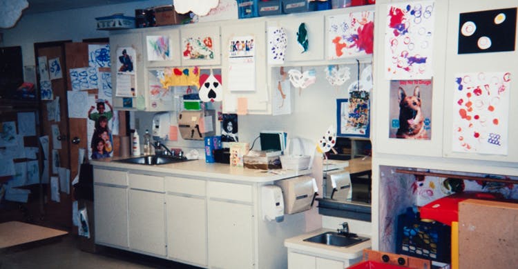Kitchen area with children's artwork displayed on cabinets and walls