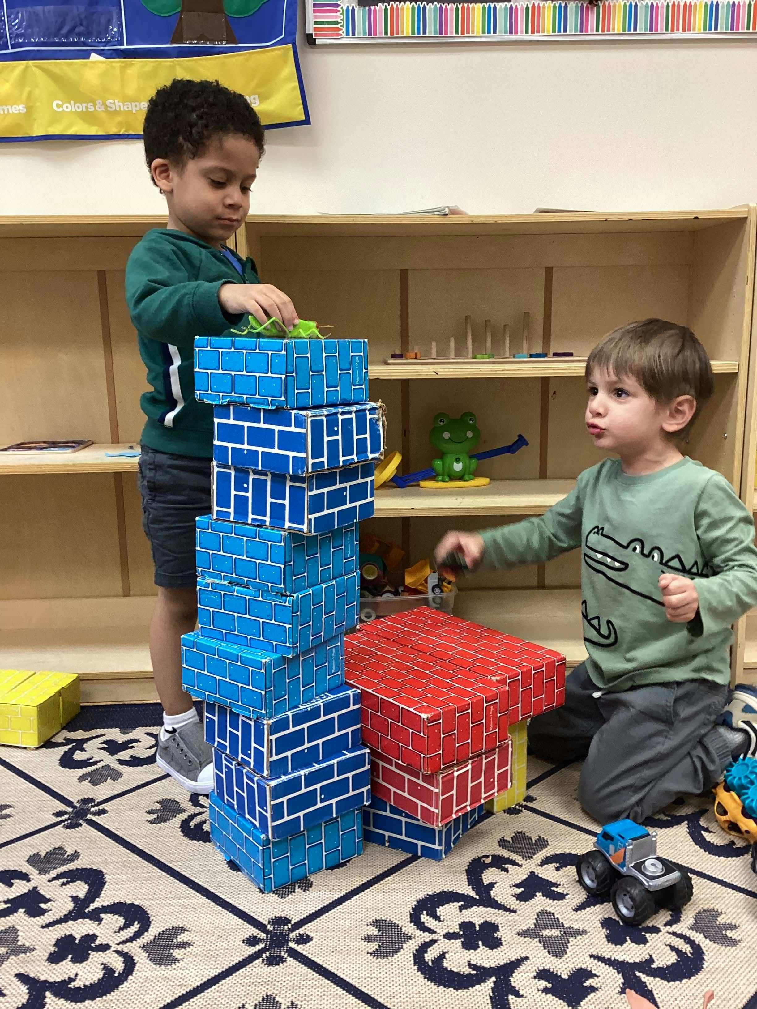 Two children playing with block toys in a classroom