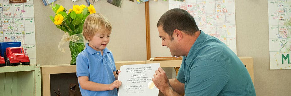 Adult and child looking at a document in a classroom