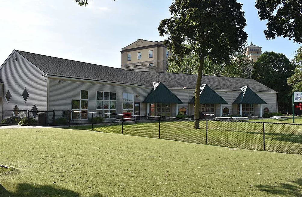 Building with multiple awnings and a grassy area in front