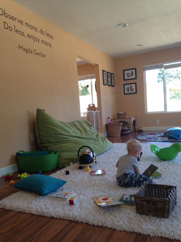 Child sitting on a rug playing with a book