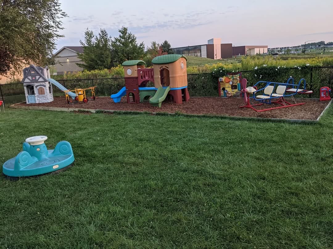 Playground with playhouses, slides, and a seesaw on wood chips