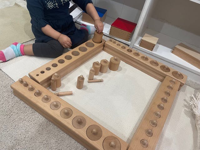 Child playing with wooden cylinder blocks