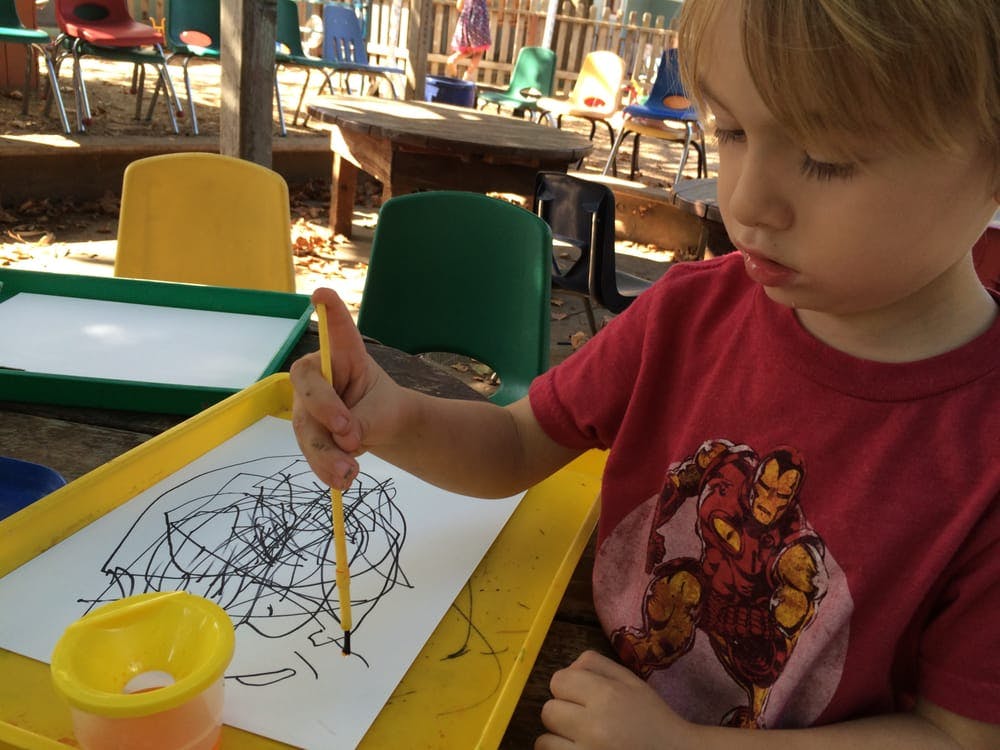 Child drawing on paper with a marker