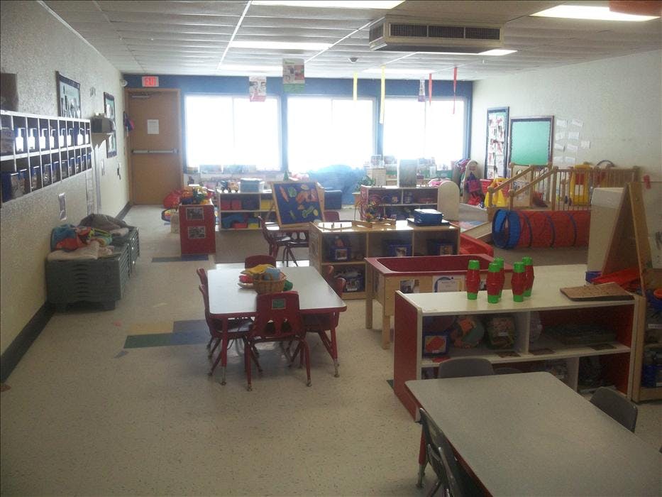 Empty colorful children's classroom with tables and play equipment
