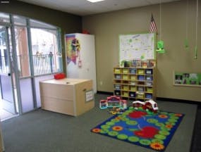 Classroom with a colorful rug, cubbies, and a whiteboard