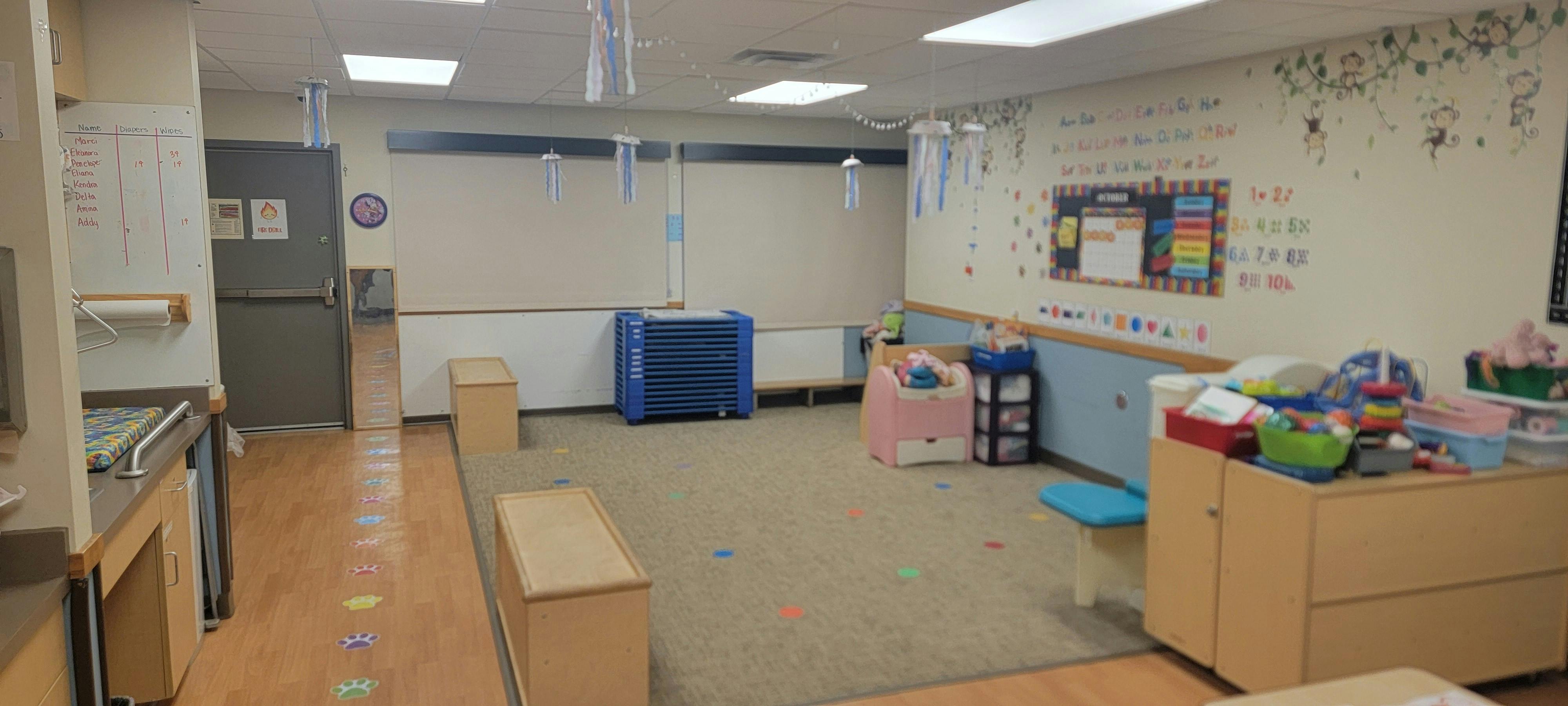 Empty child care classroom with educational wall decorations and toy storage
