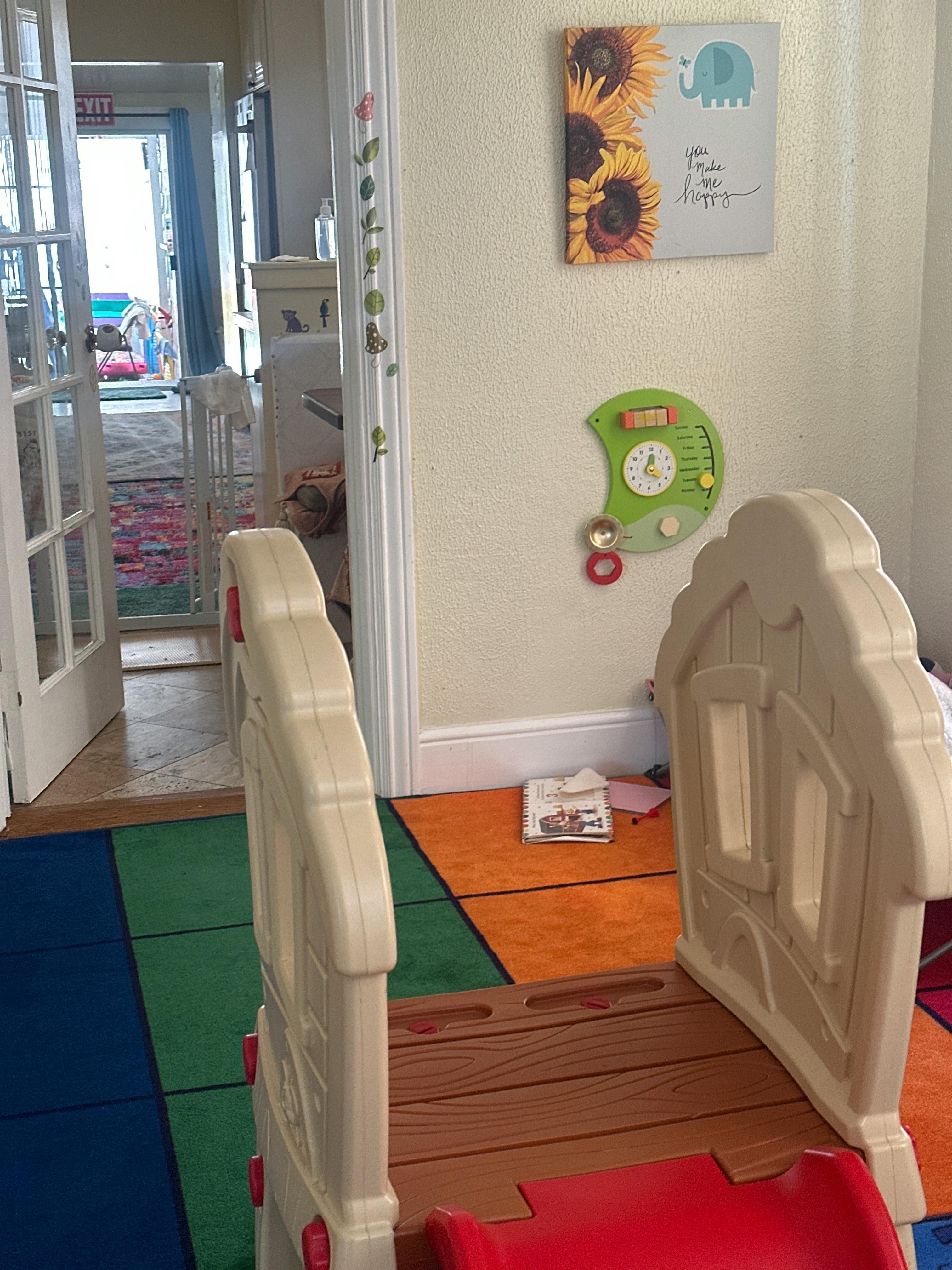 Indoor play area with a small slide and colorful floor mats