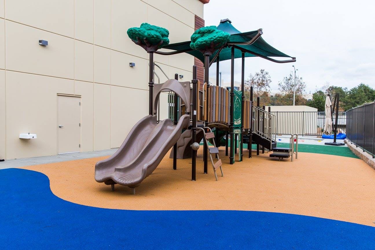 Playground with slides and climbing structures on a soft surface