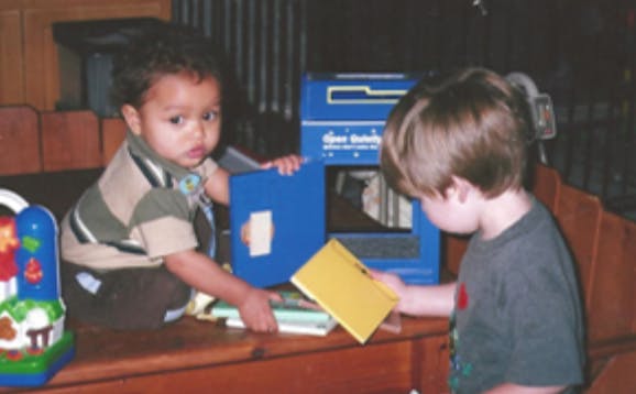 Two children playing with books
