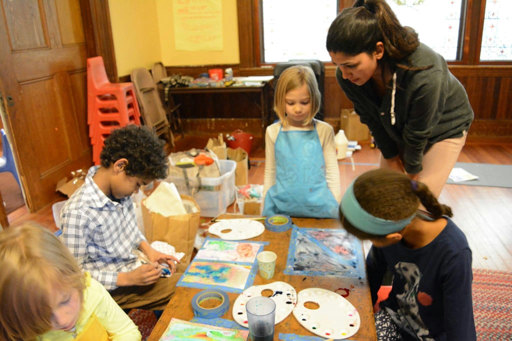 Adult and children painting at a table