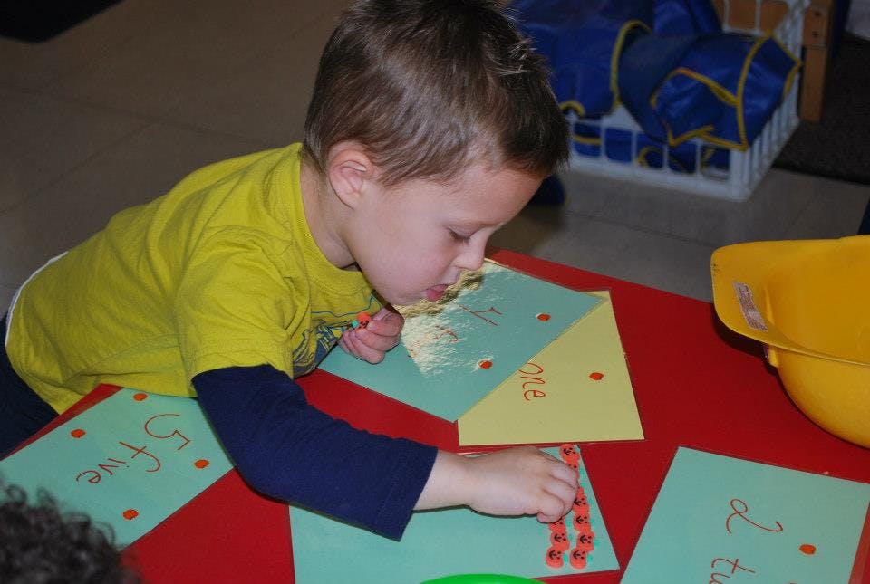 Child working on a craft project at a table