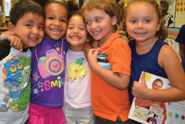 Five children standing close together, smiling