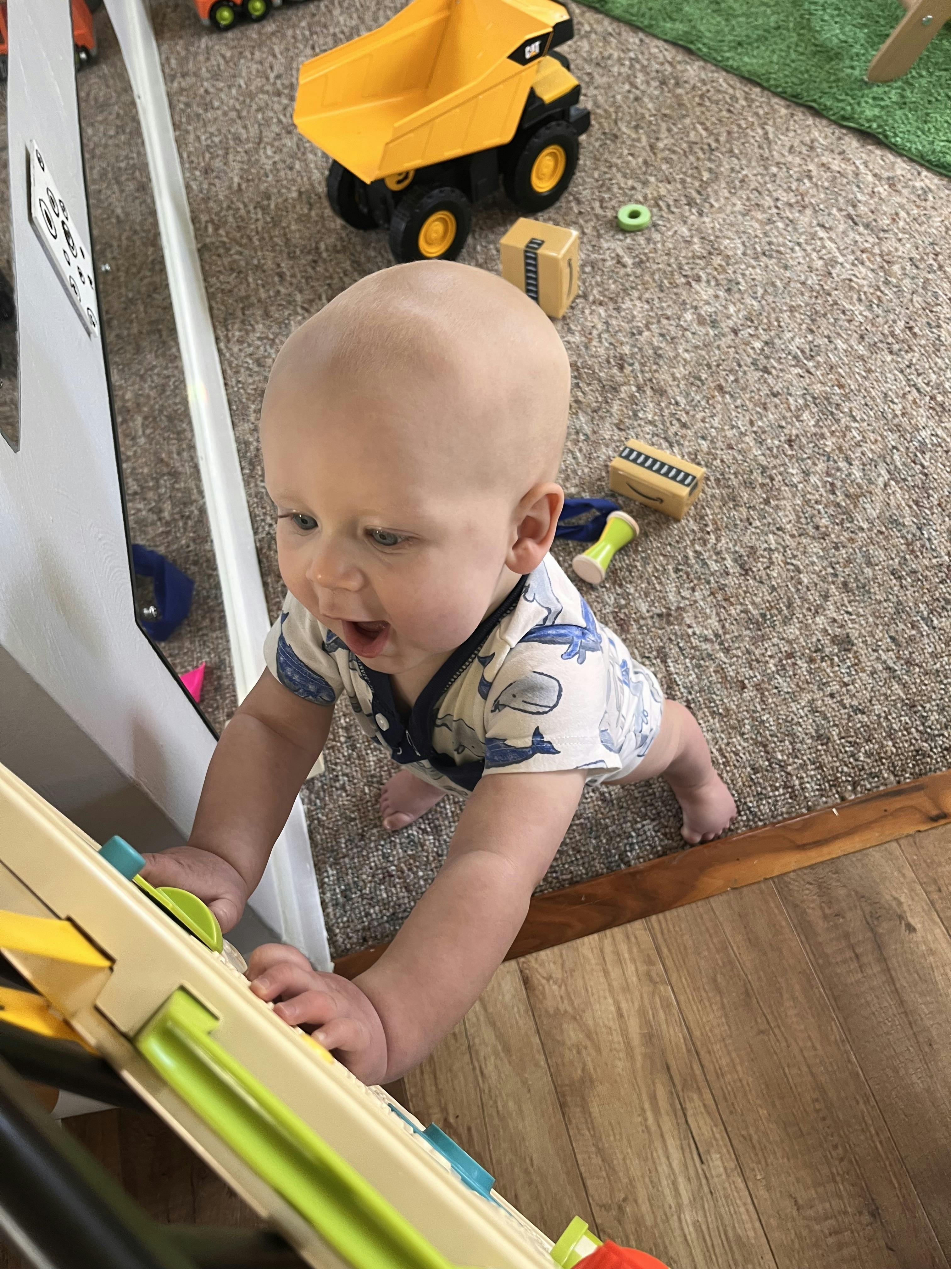 Child standing and playing with an activity toy