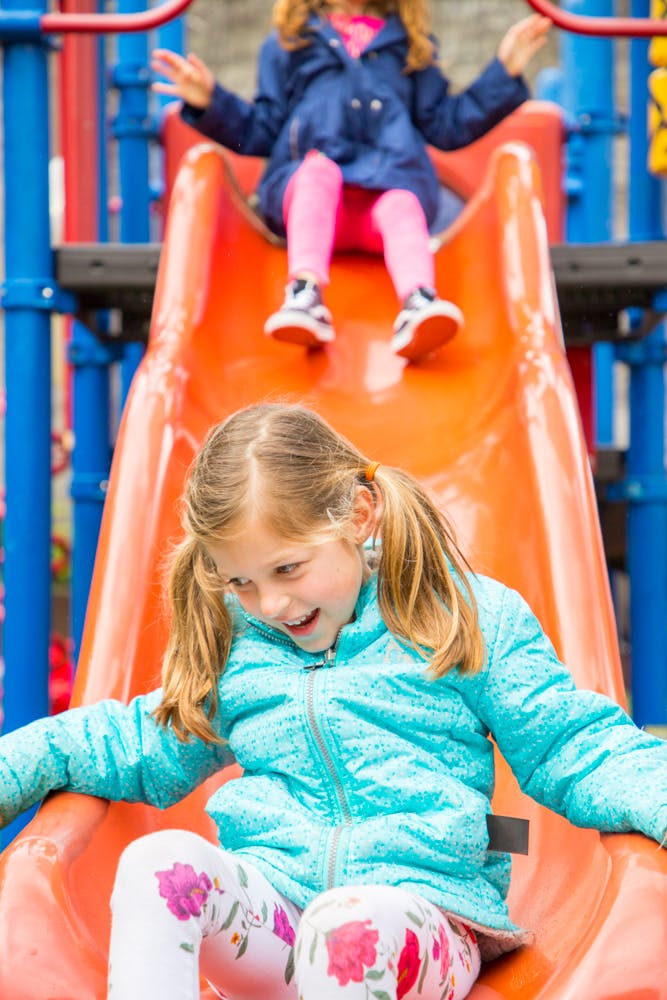 Two children on an orange slide