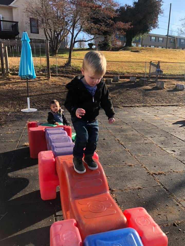 Child walking on a colorful plastic play structure outdoors